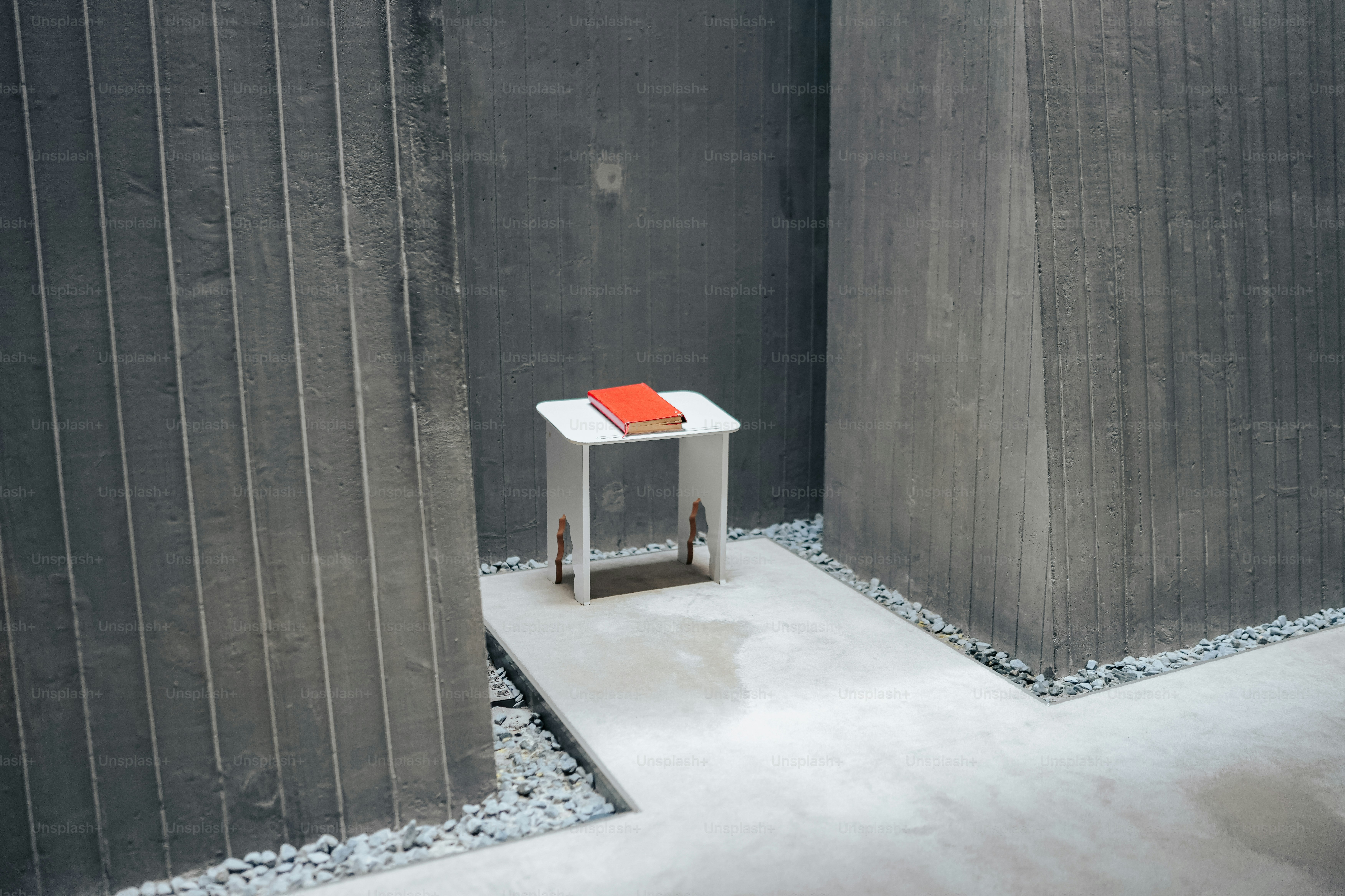 a small white table with a red book on top of it