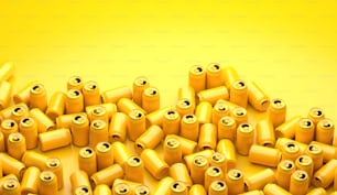 a pile of yellow batteries on a yellow background