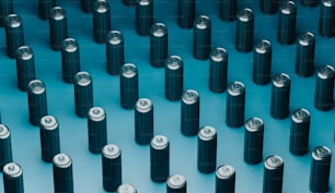 a large group of black batteries on a blue surface
