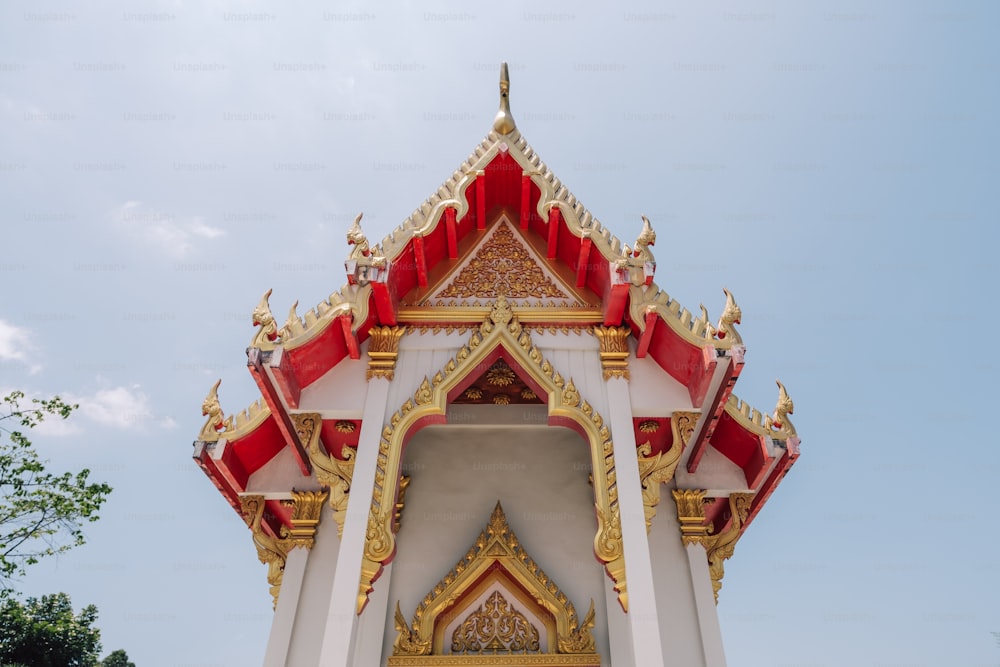 a white and gold building with a red roof