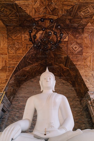a large white buddha statue sitting in a room
