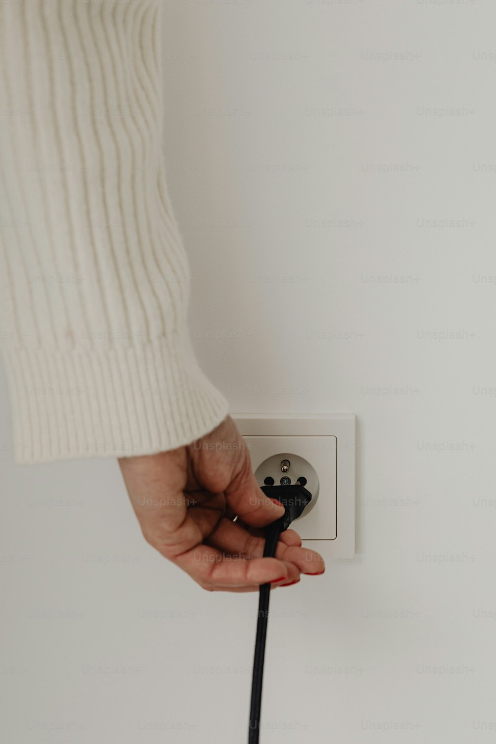 a person is plugging in to a wall outlet