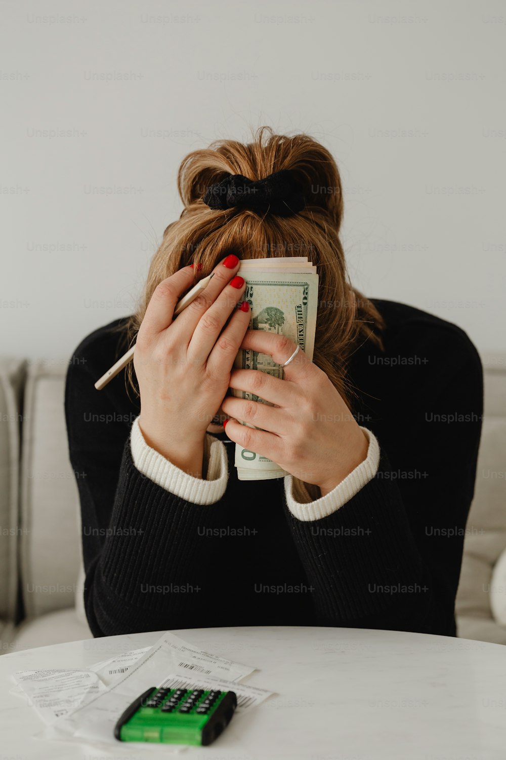 una donna seduta a un tavolo che tiene una pila di soldi