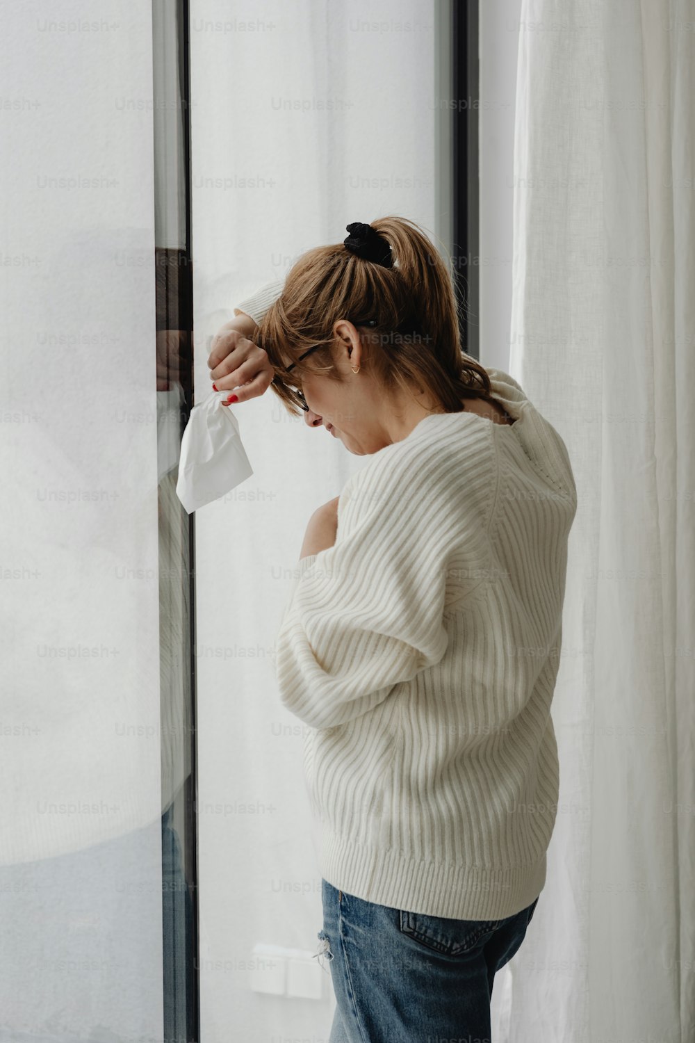 a woman standing in front of a glass door