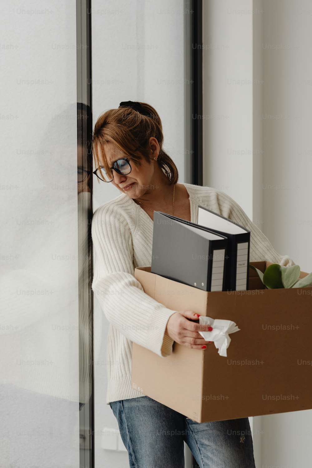 a woman carrying a box with a computer in it