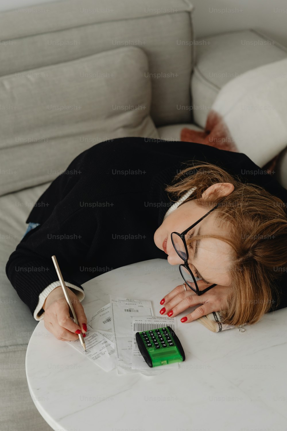 a woman laying on top of a white table next to a calculator