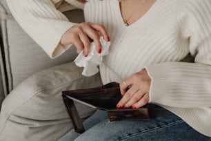 a woman sitting on a couch holding a wallet