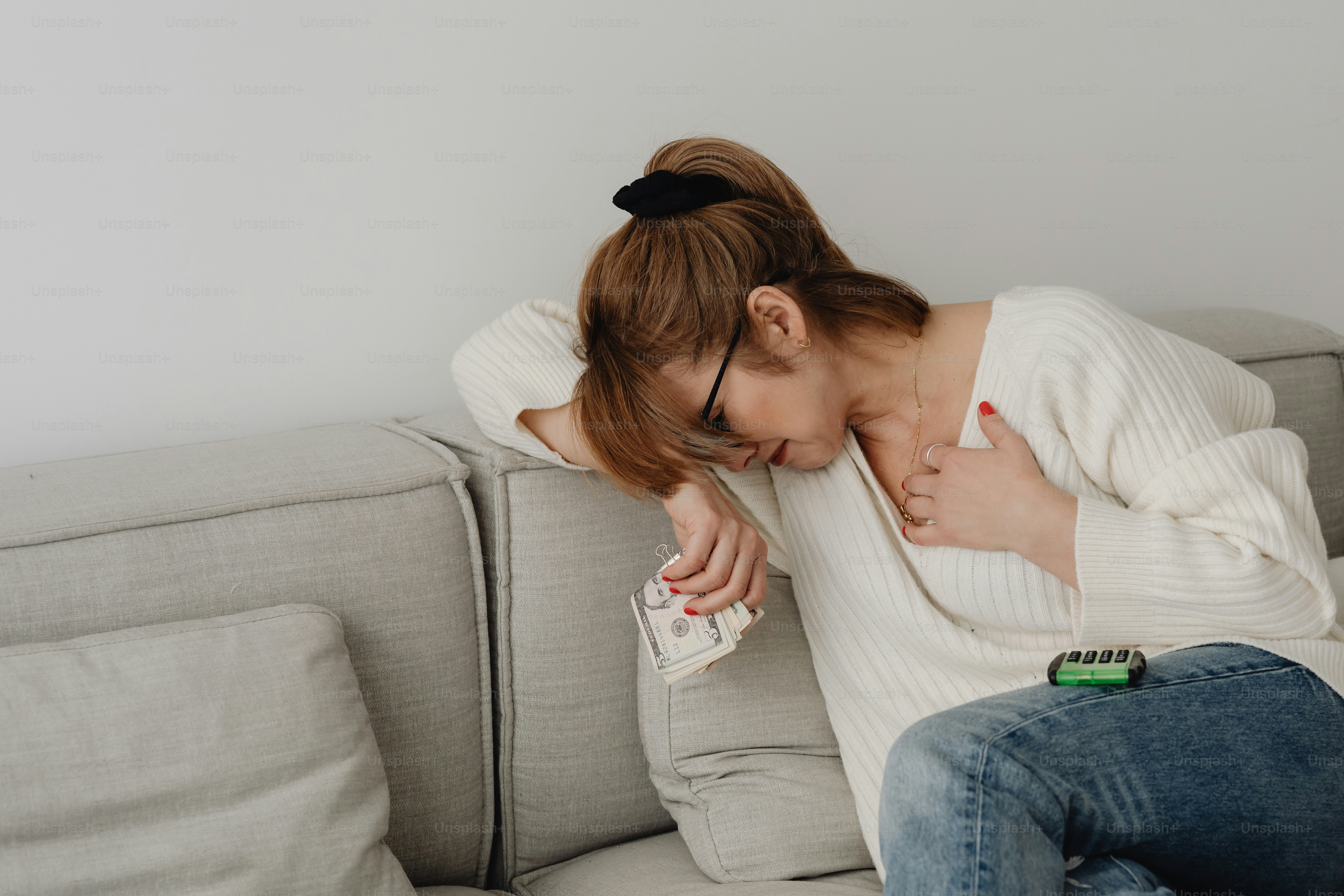 a woman sitting on a couch with her head down