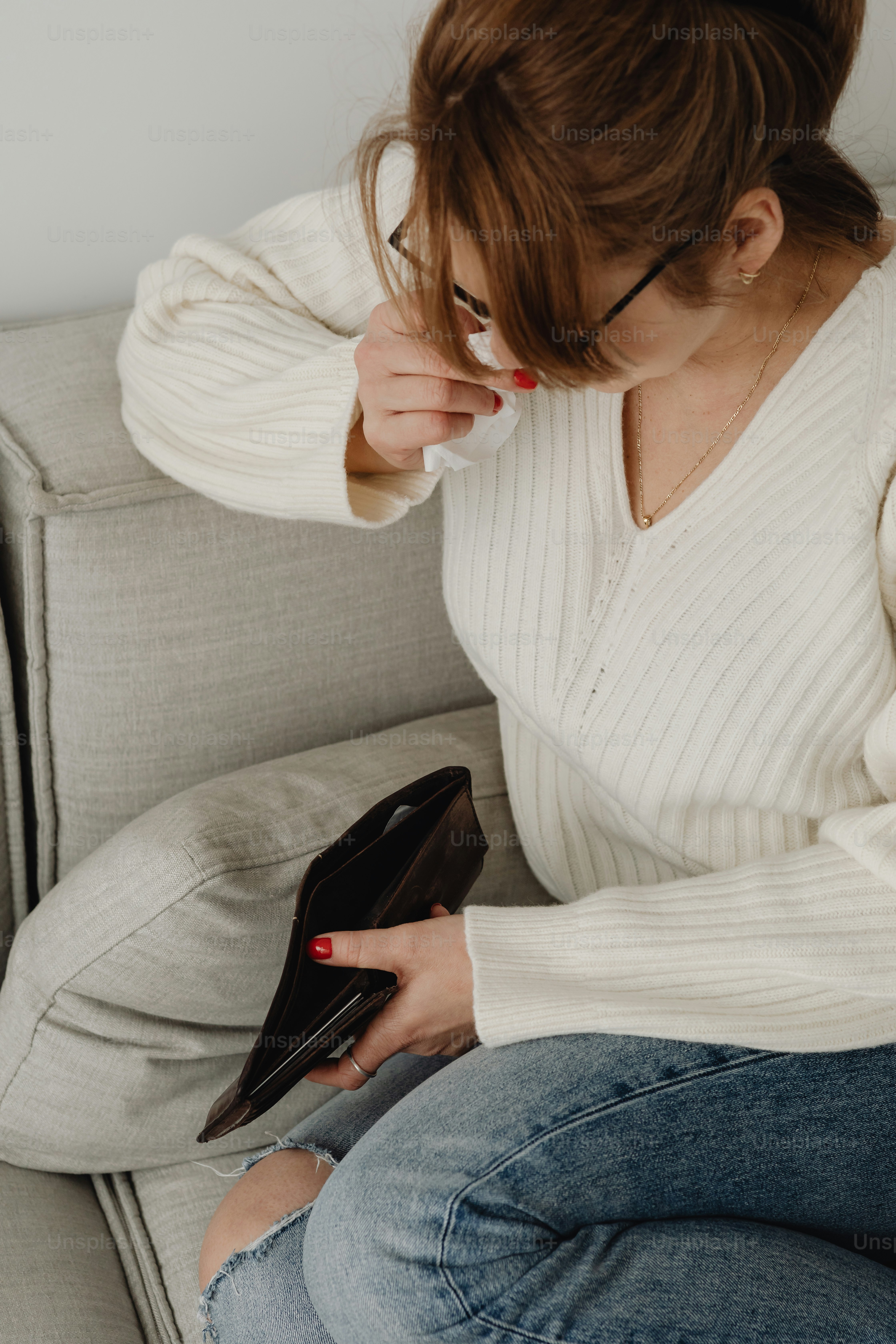 a woman sitting on a couch holding a purse