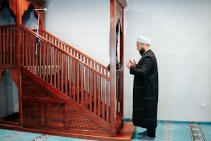 Un homme debout devant un escalier en bois