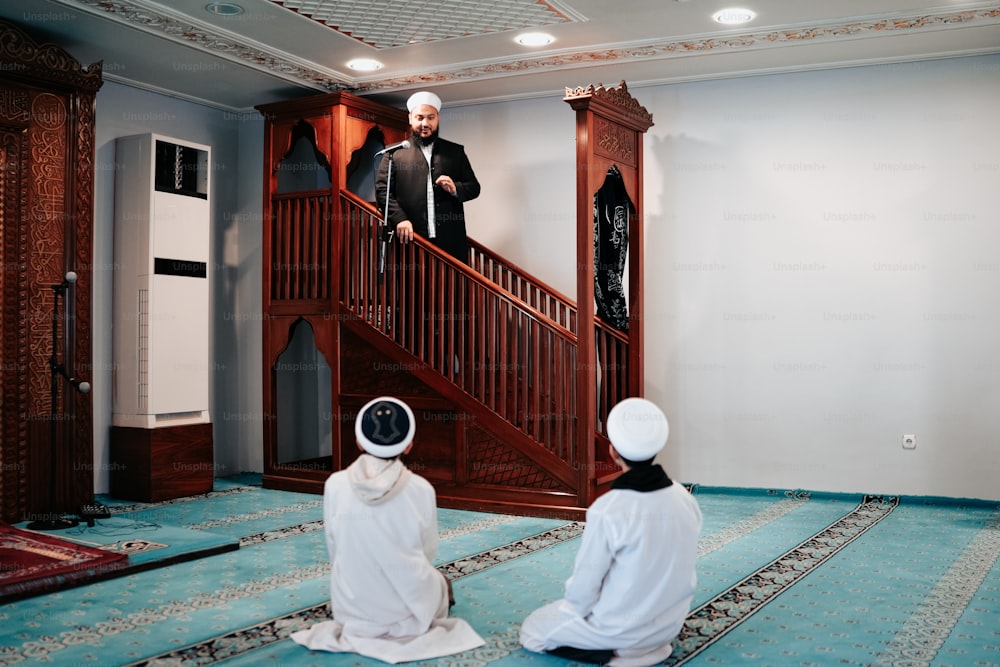 a group of men sitting on top of a blue rug