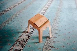 a small wooden stool sitting on top of a rug