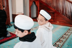 a young boy in a white outfit and a young boy in a black and white