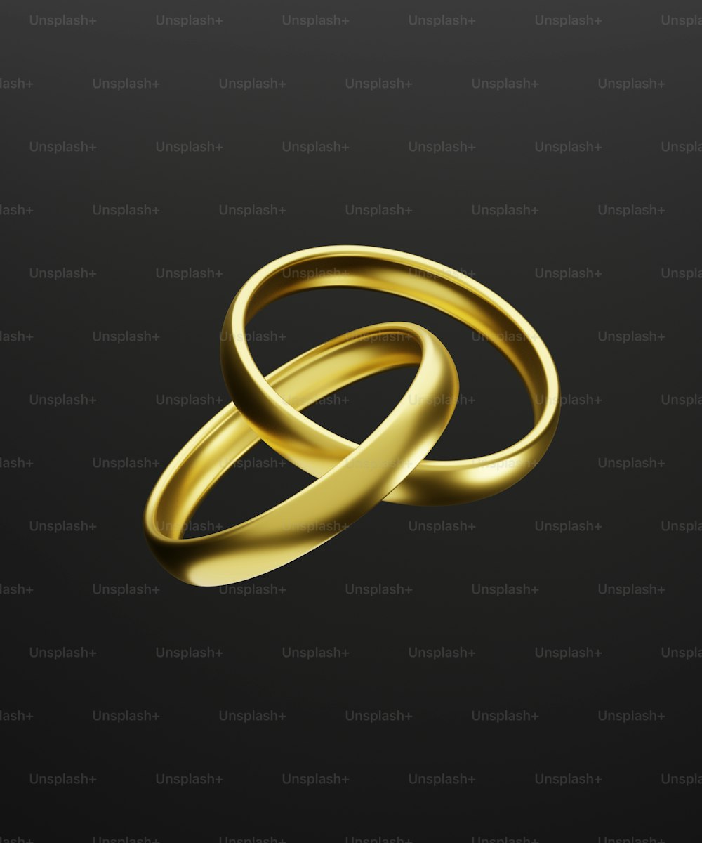 two gold wedding rings on a black background