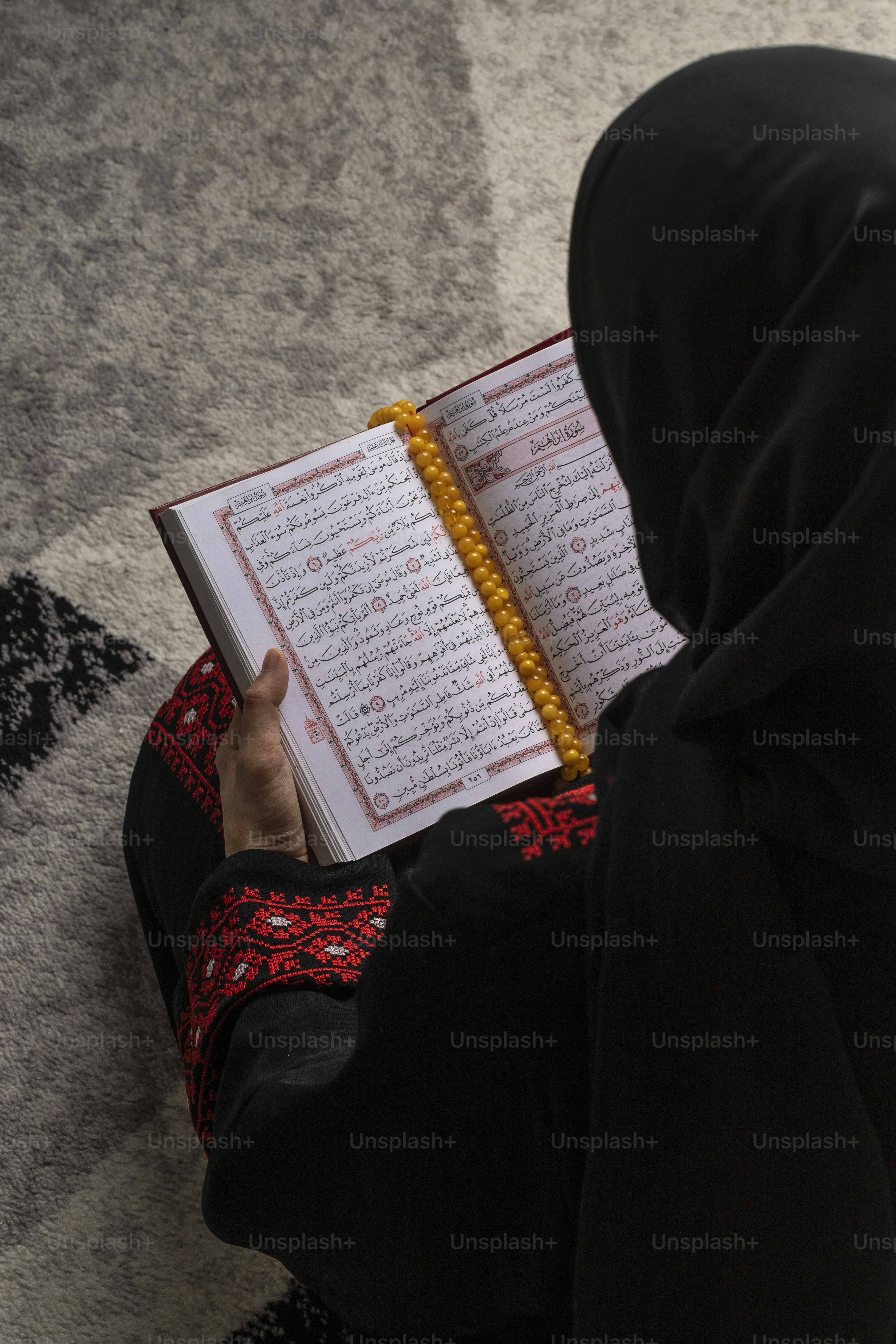 seseorang yang duduk di lantai membaca buku
