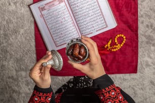 a person holding a jar of nuts in front of a book