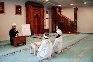 a couple of people sitting on top of a rug