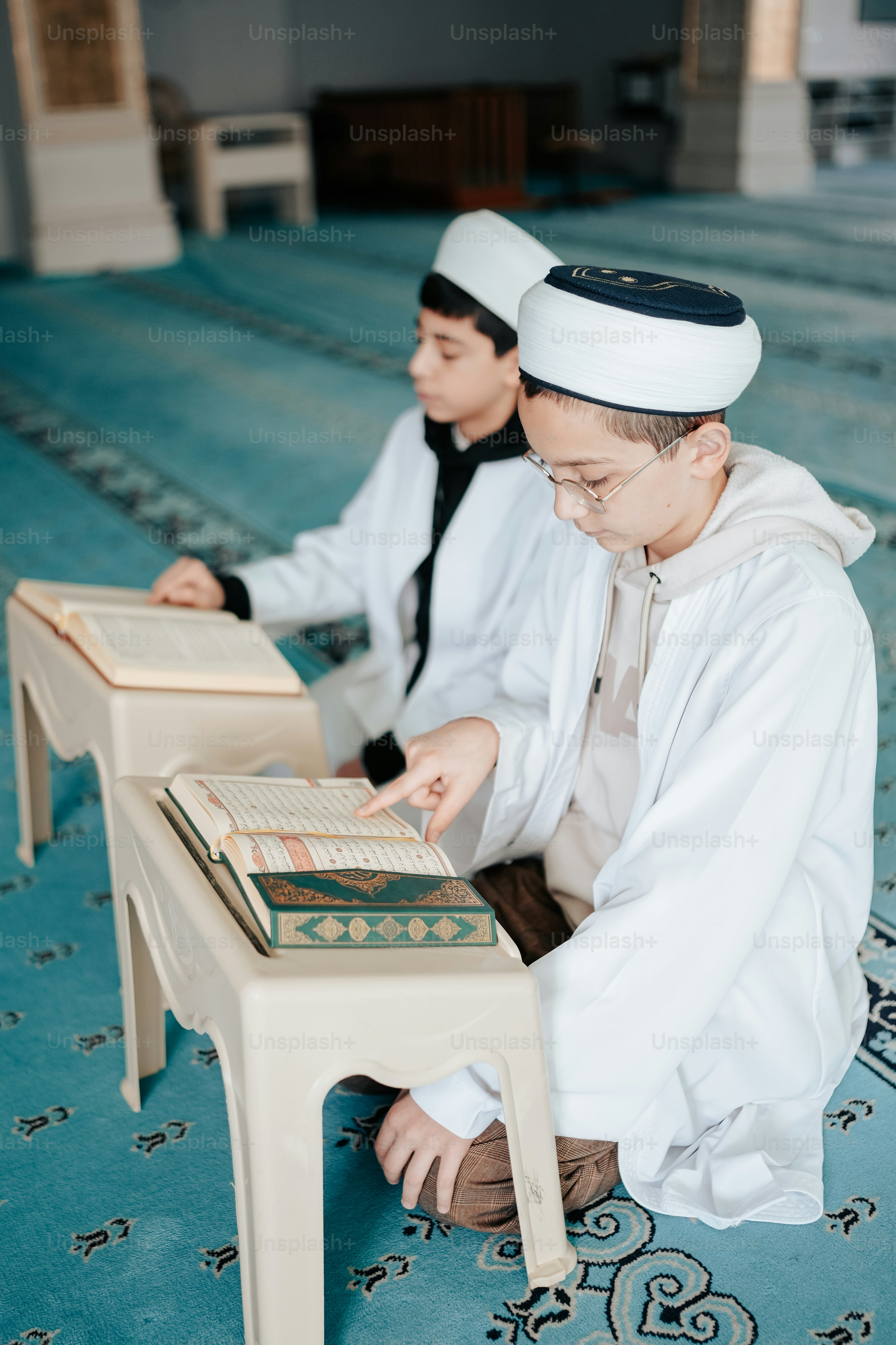 a couple of men sitting on top of a blue rug