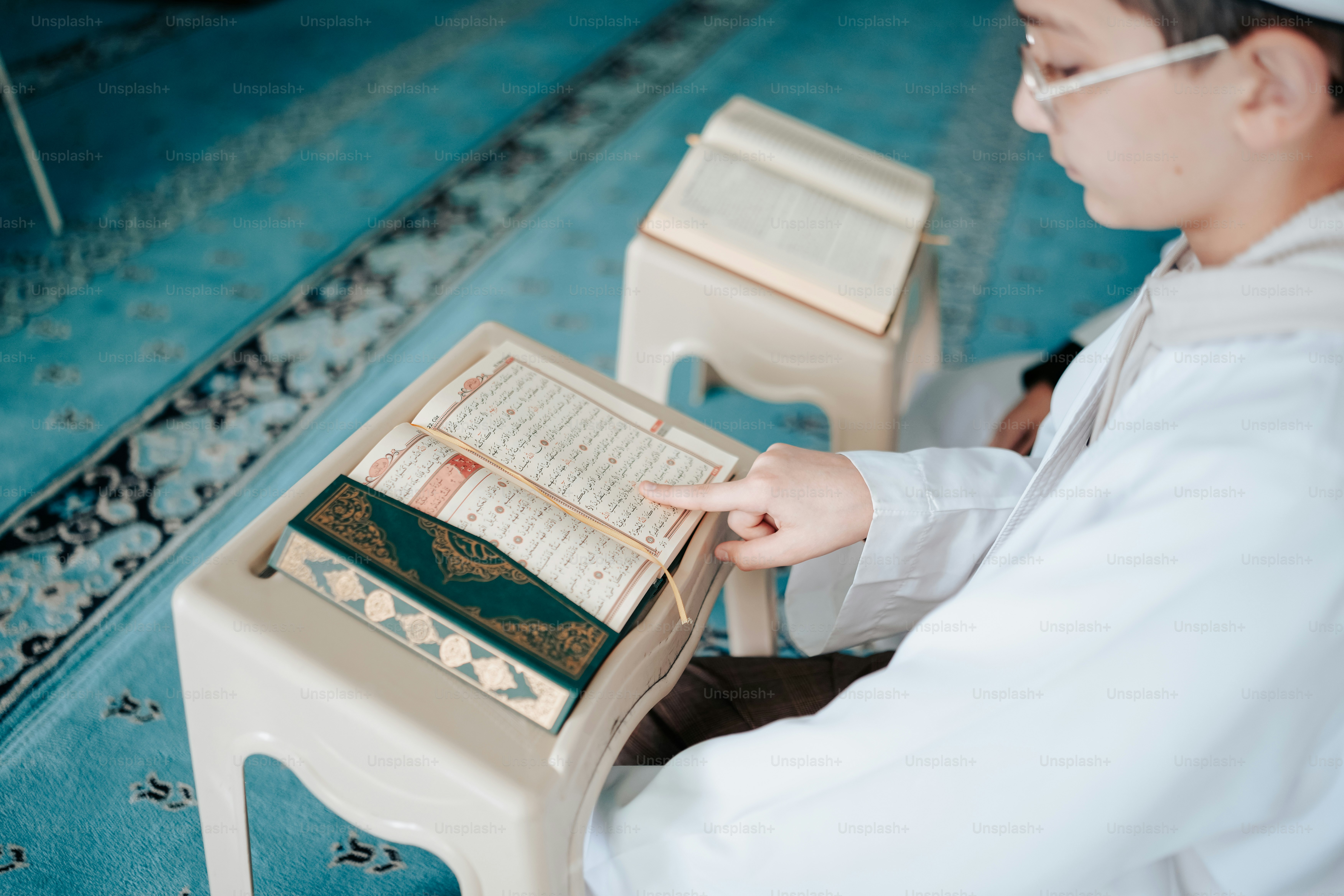 une personne assise à une table avec un livre dessus