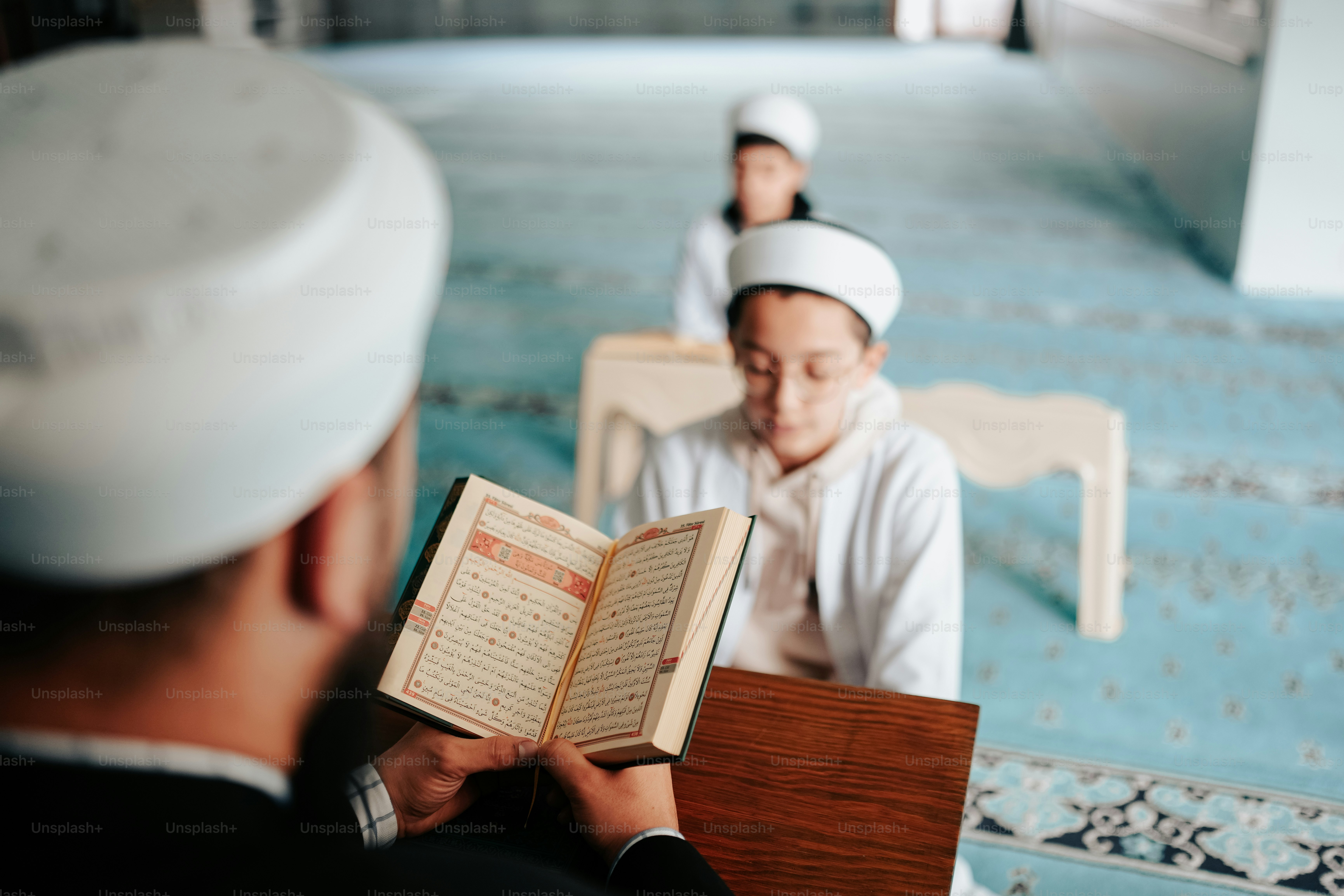 a man reading a book in a room with other people