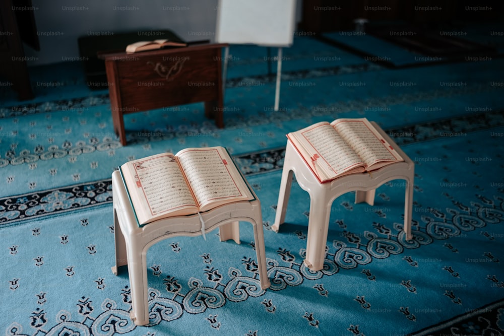 quelques petites tables en bois posées sur un tapis bleu