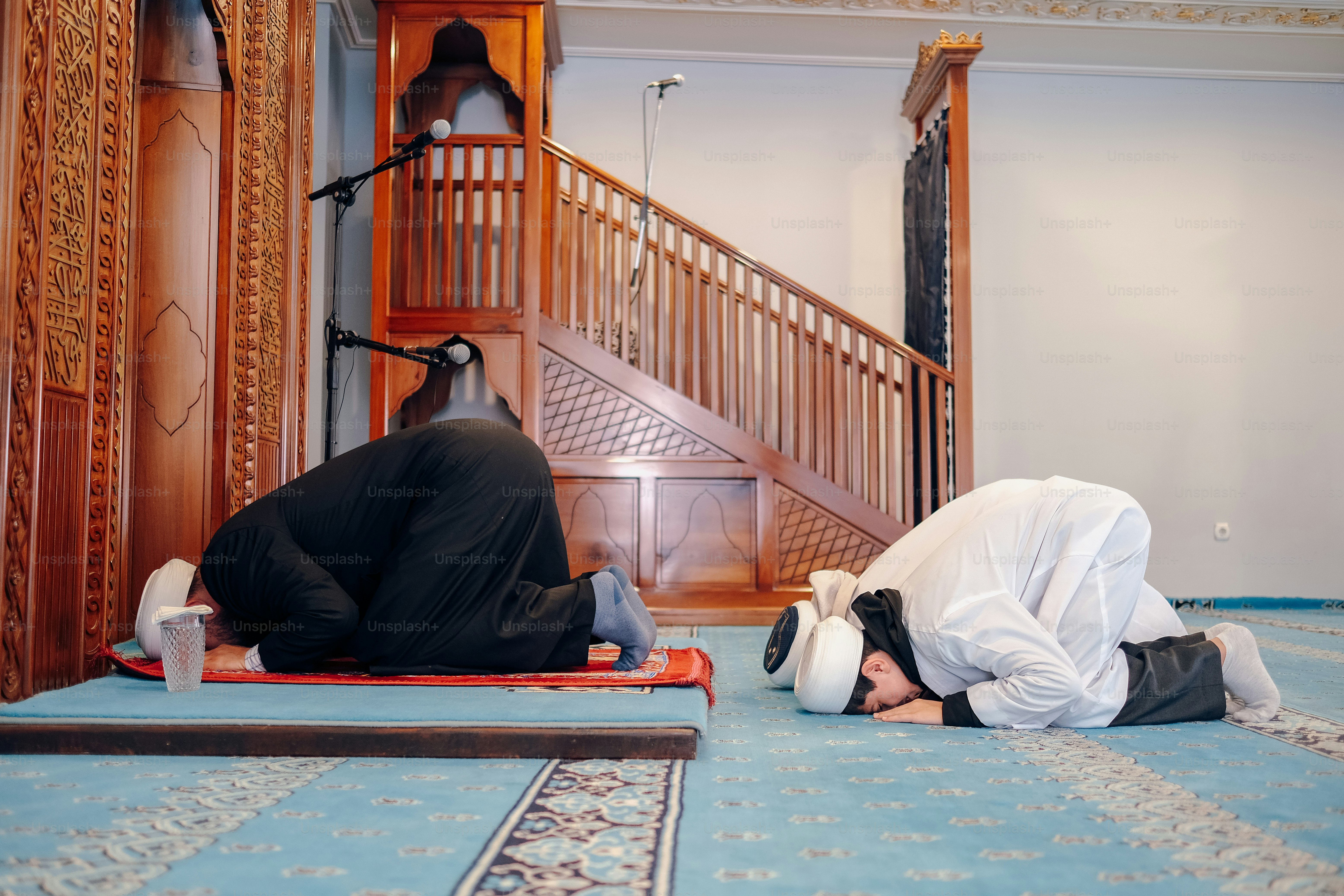 a couple of men laying on top of a blue carpet