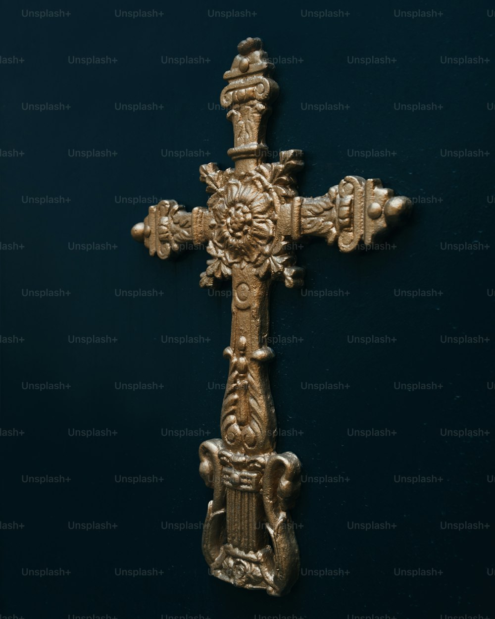 une croix d’or avec une tête de lion dessus