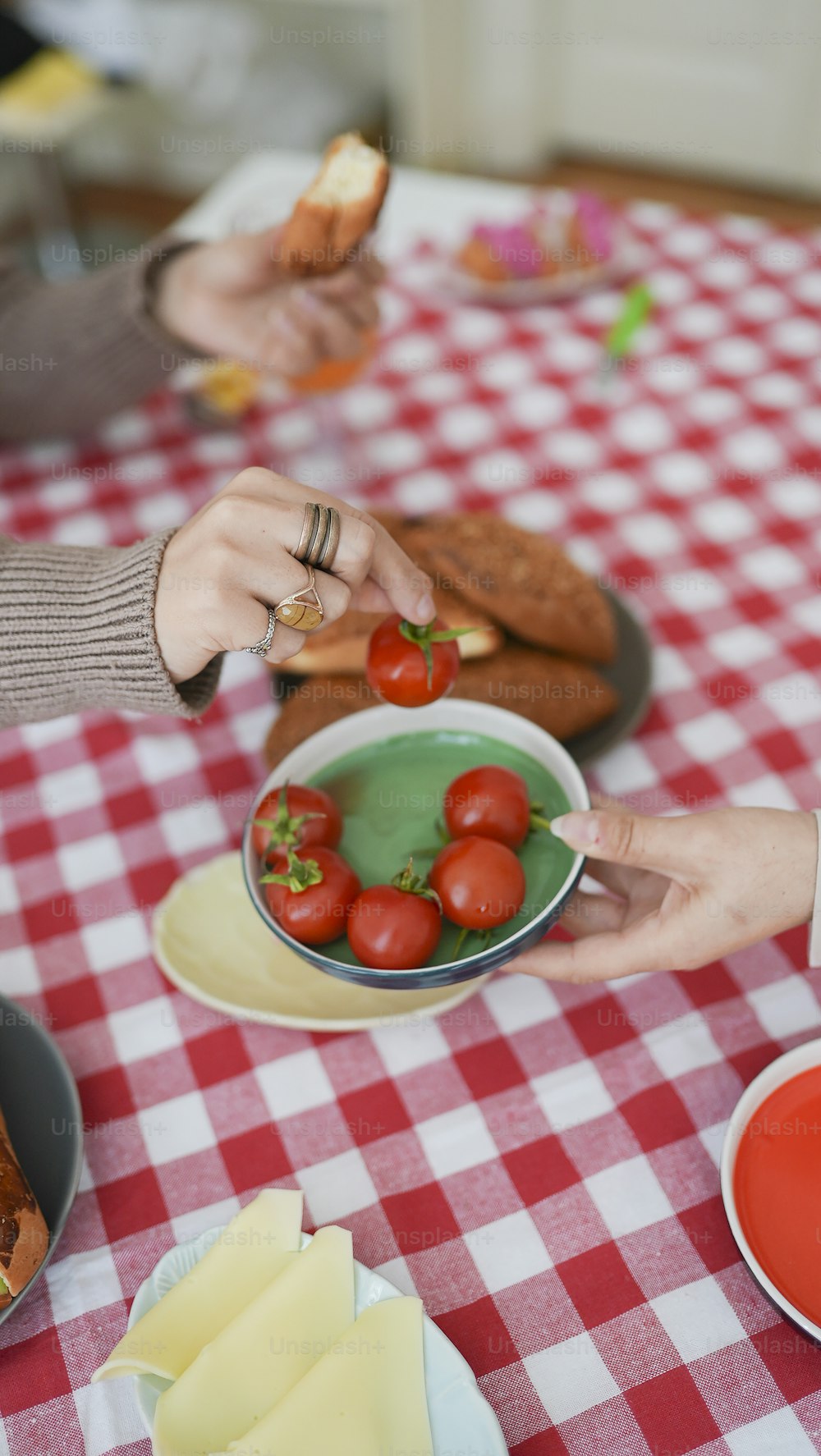 Eine Person hält eine Schüssel Tomaten auf einem Tisch