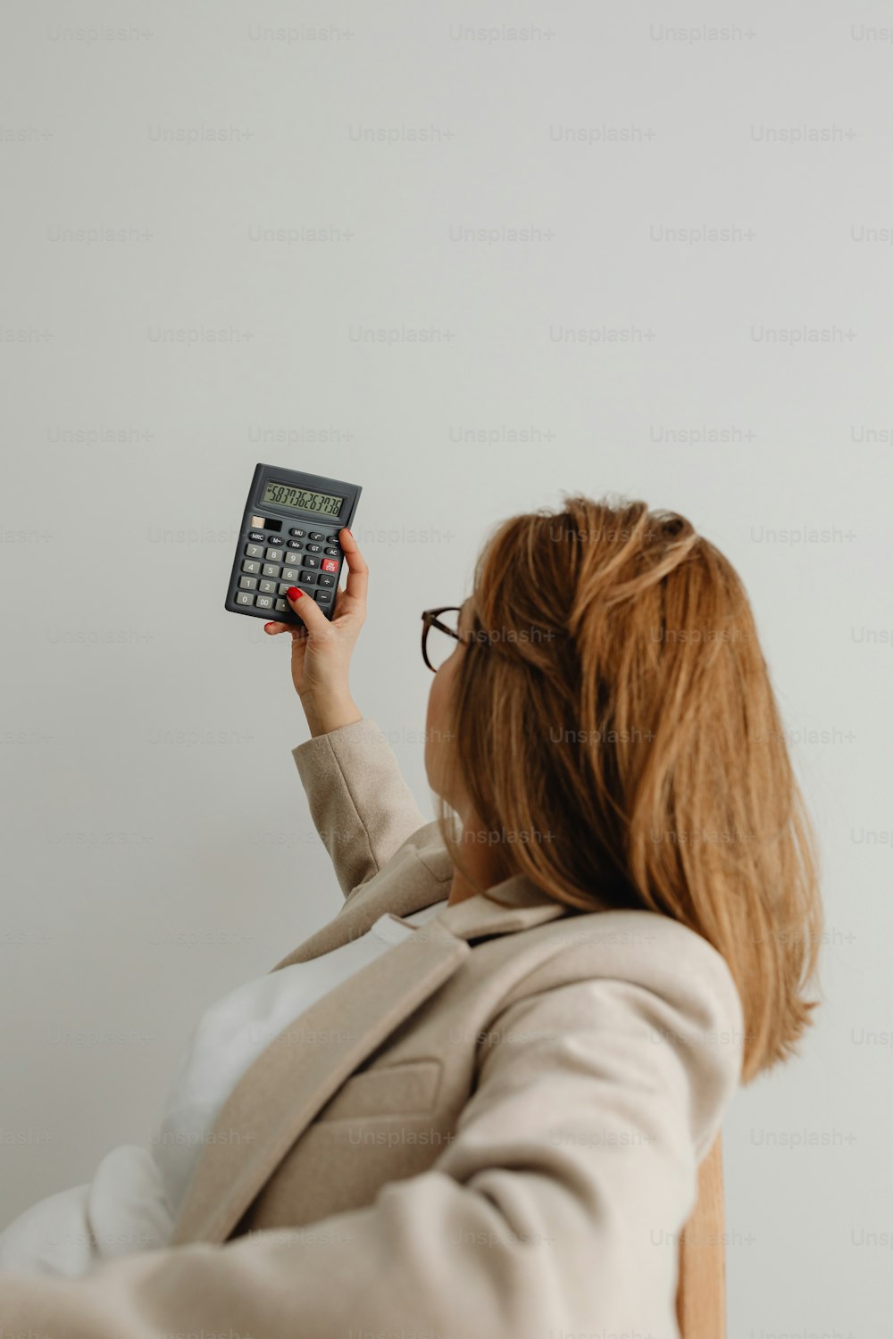 a woman holding a remote control up to a wall