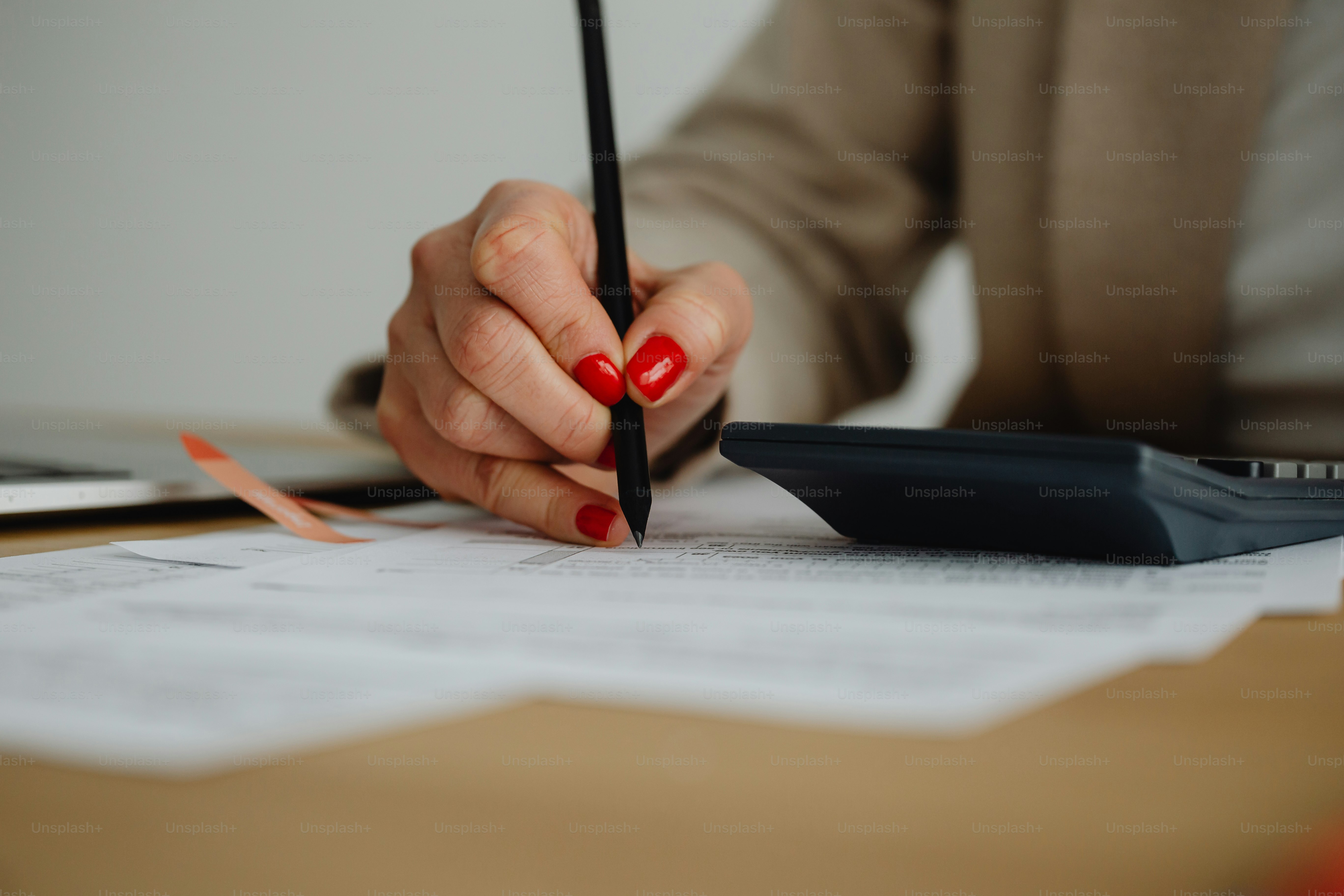 a woman sitting at a desk writing on a piece of paper