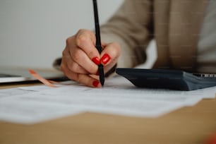a woman sitting at a desk writing on a piece of paper