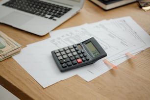 a calculator sitting on top of a desk next to a laptop