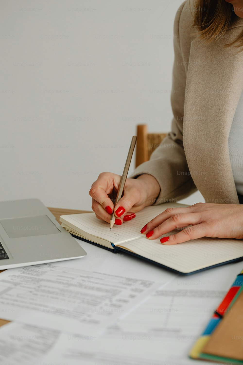 a woman sitting at a desk writing on a notebook