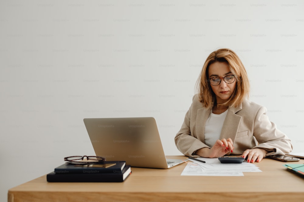 a woman sitting at a desk in front of a laptop computer