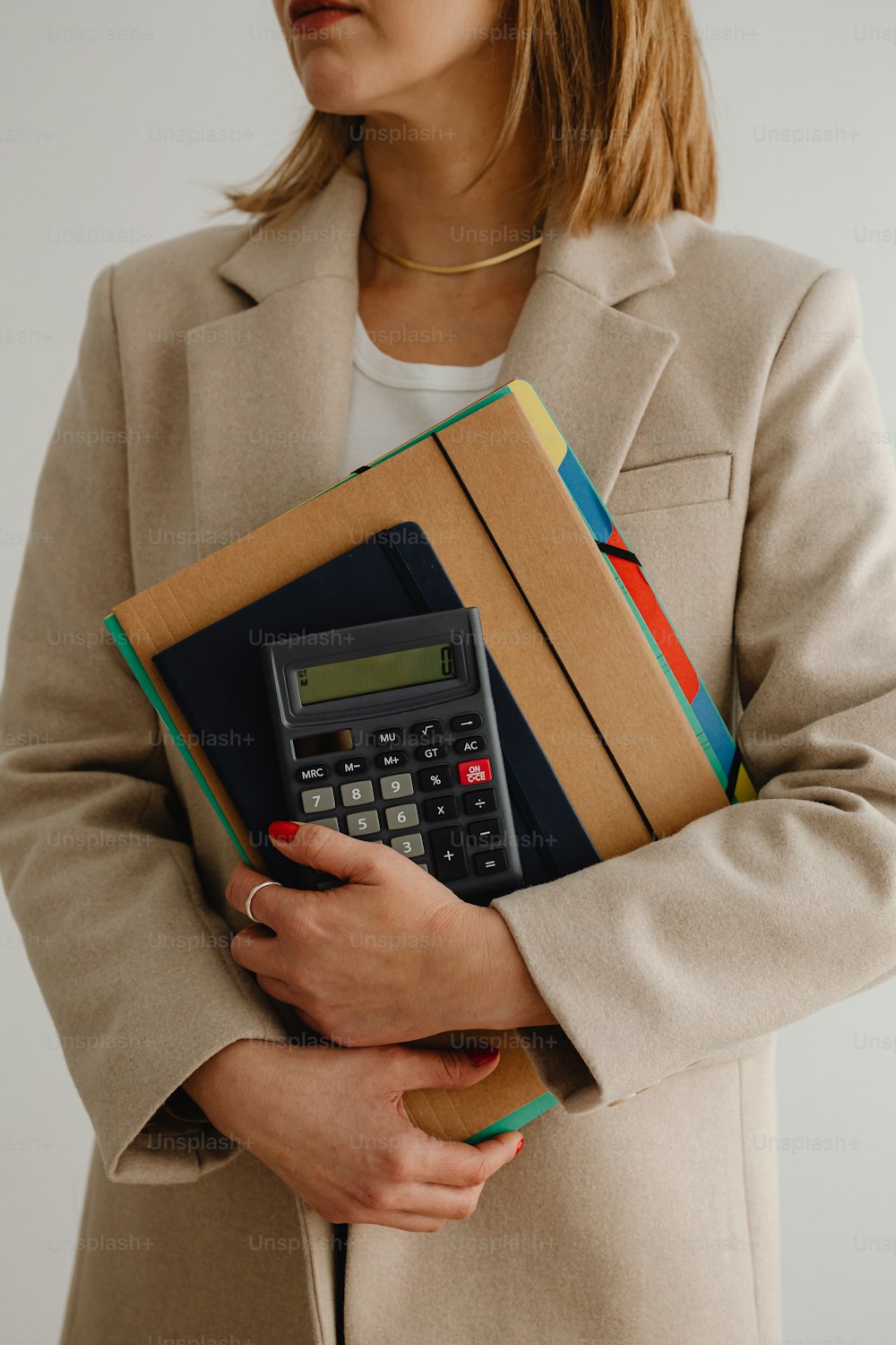 uma mulher segurando uma calculadora e pastas