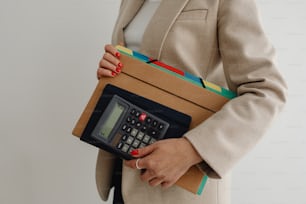 a woman holding a calculator and a folder