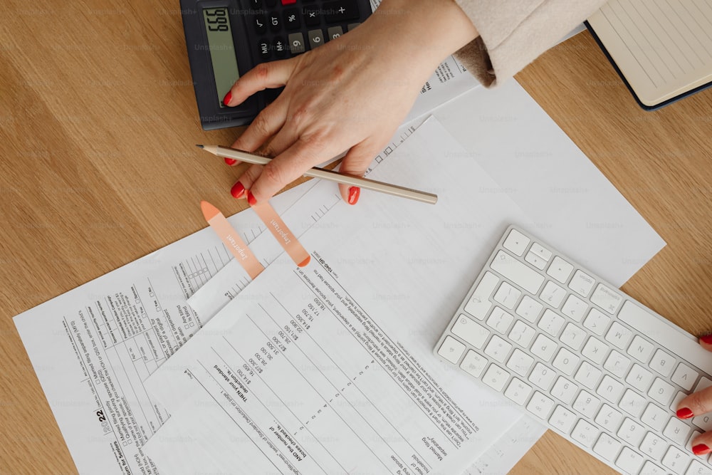 a woman sitting at a desk with papers and a calculator