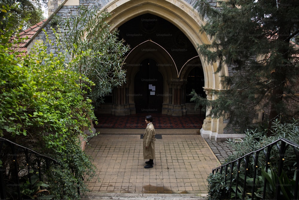 um homem em pé na frente de uma entrada da igreja