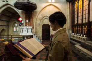 Una persona sosteniendo un libro en una iglesia