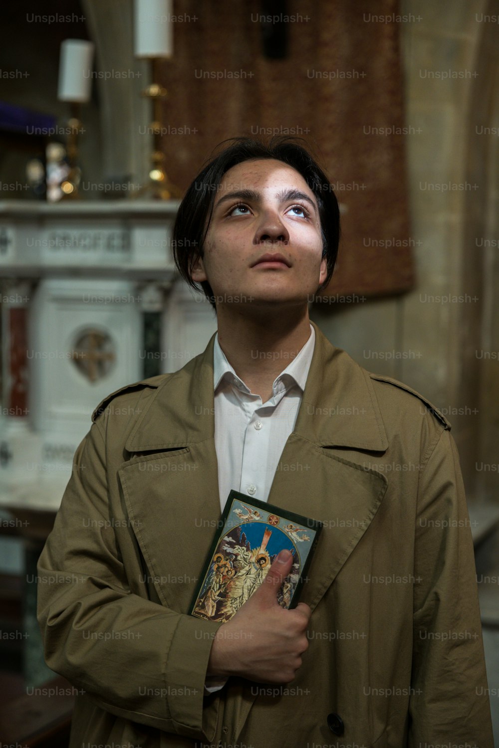a man in a trench coat holding a book