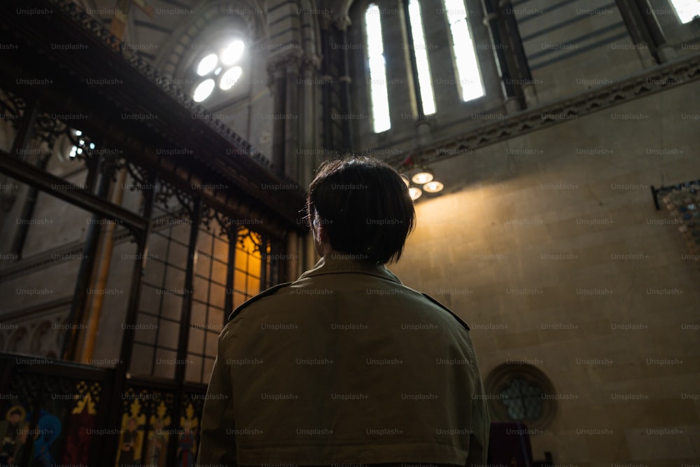 um homem em pé na frente de uma janela em uma igreja