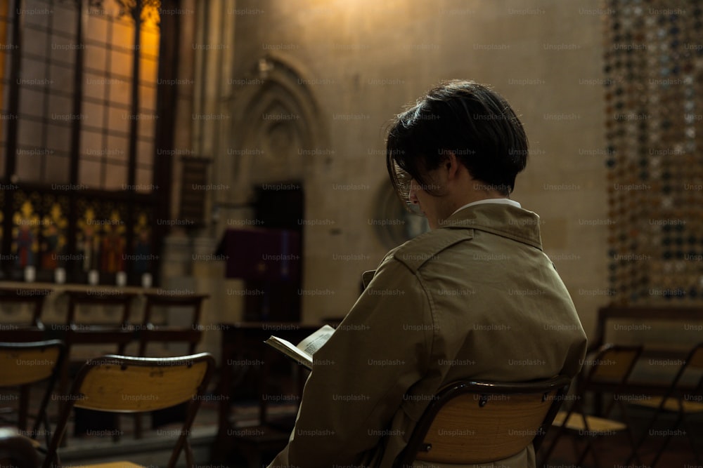 una persona seduta su una sedia che legge un libro