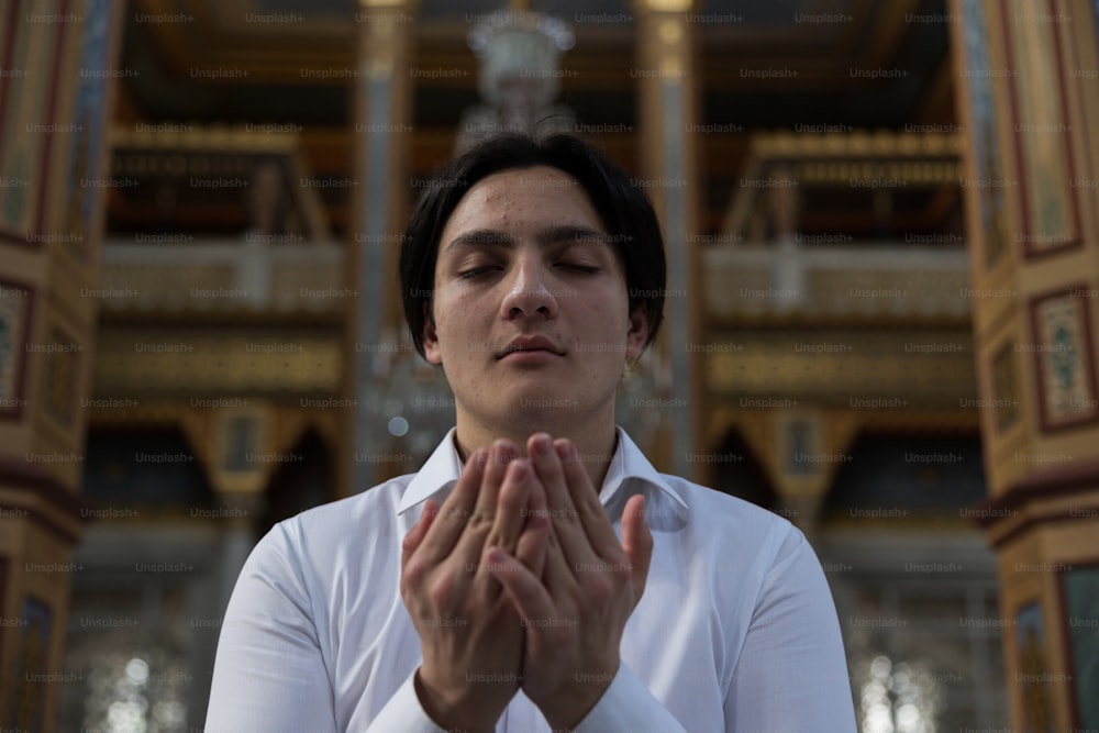 Una mujer con una camisa blanca está orando