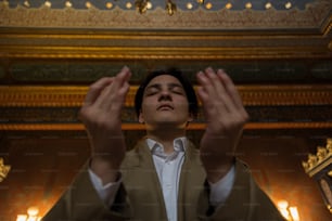 a man standing in front of a ceiling with his hands in the air