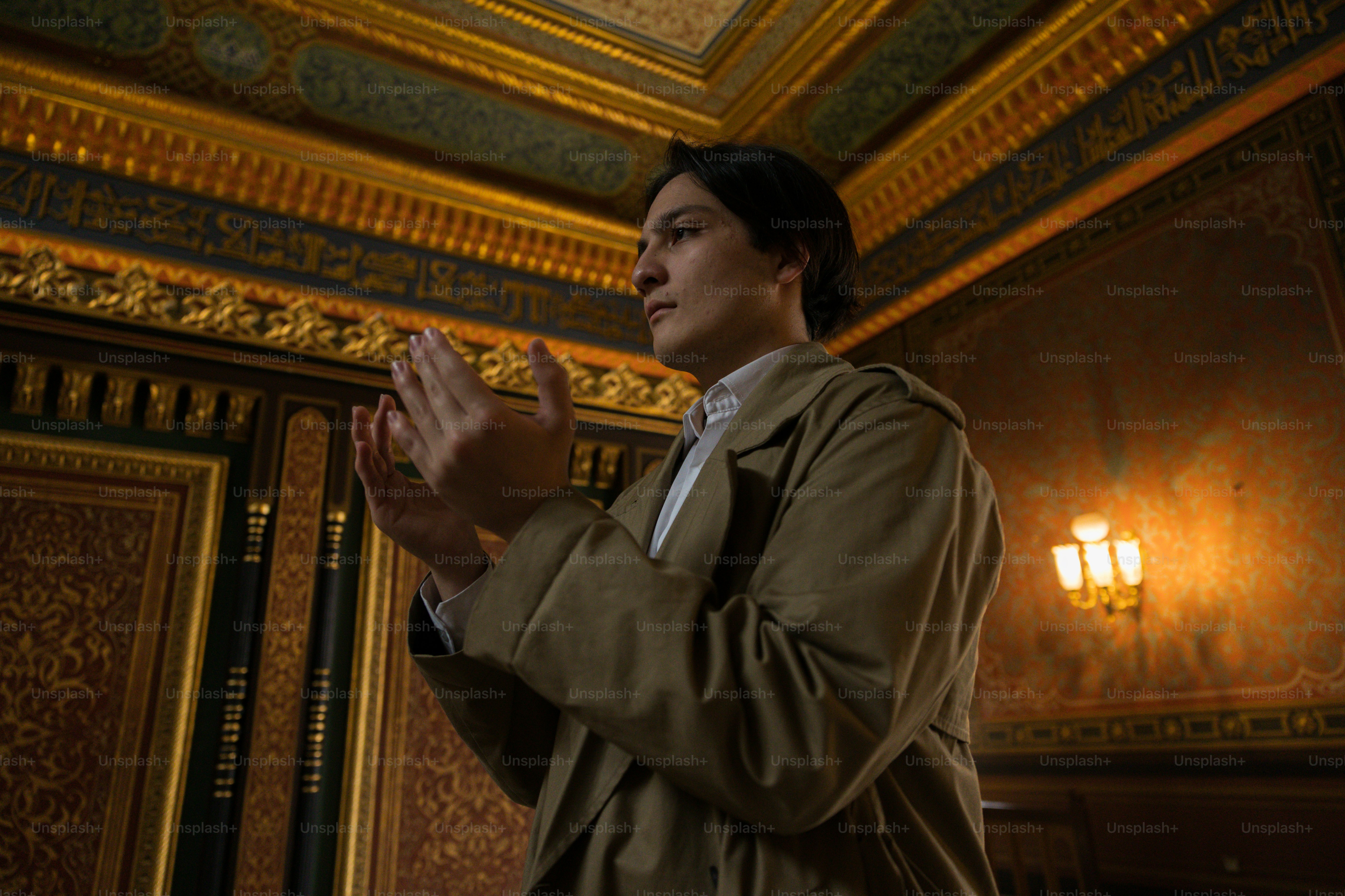 a man standing in a room holding his hands together