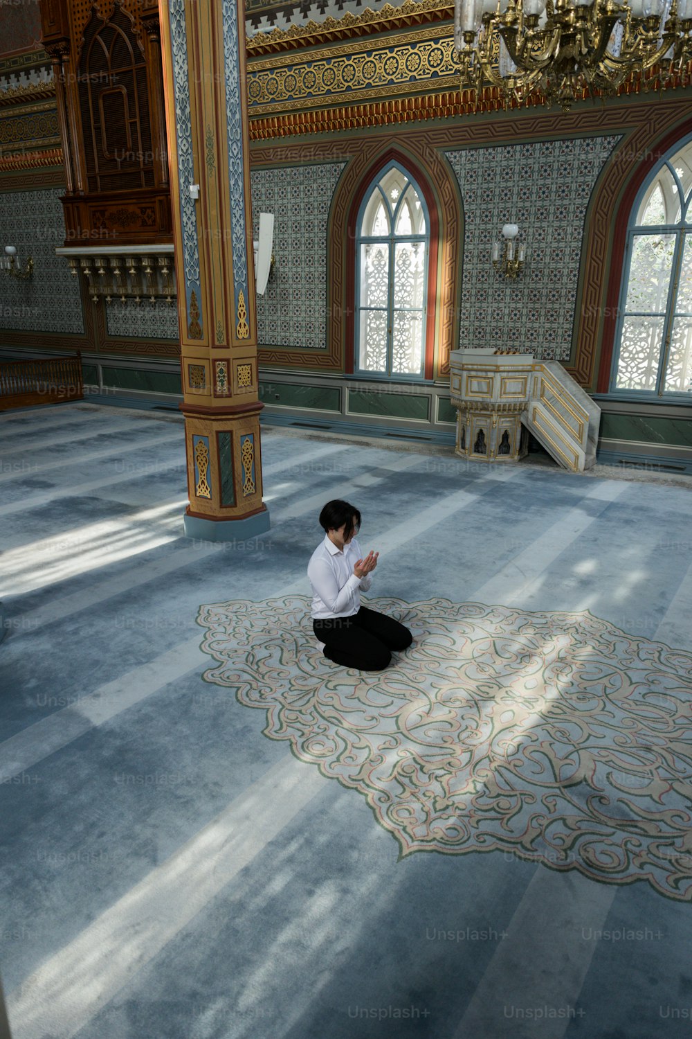 una persona seduta su un tappeto in una stanza