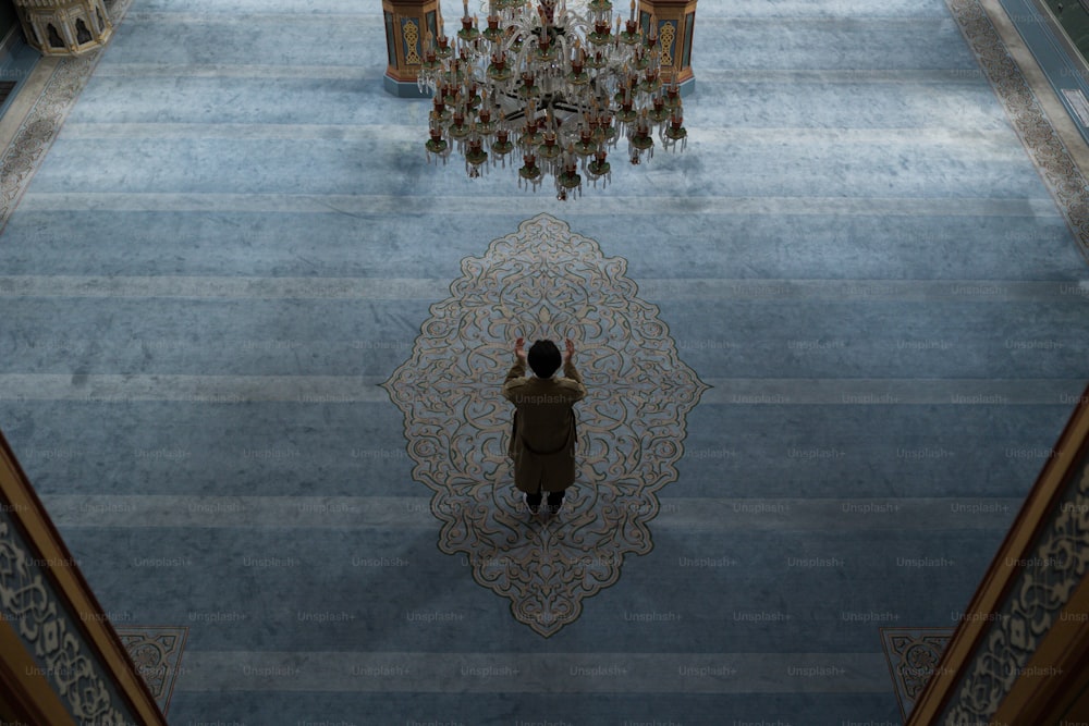 a woman standing in a large room with a chandelier