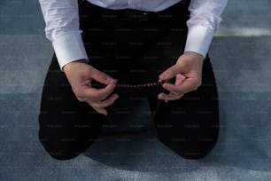 Una persona sentada en el suelo sosteniendo una cuerda