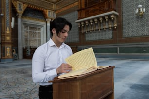 a man in a white shirt is reading a book