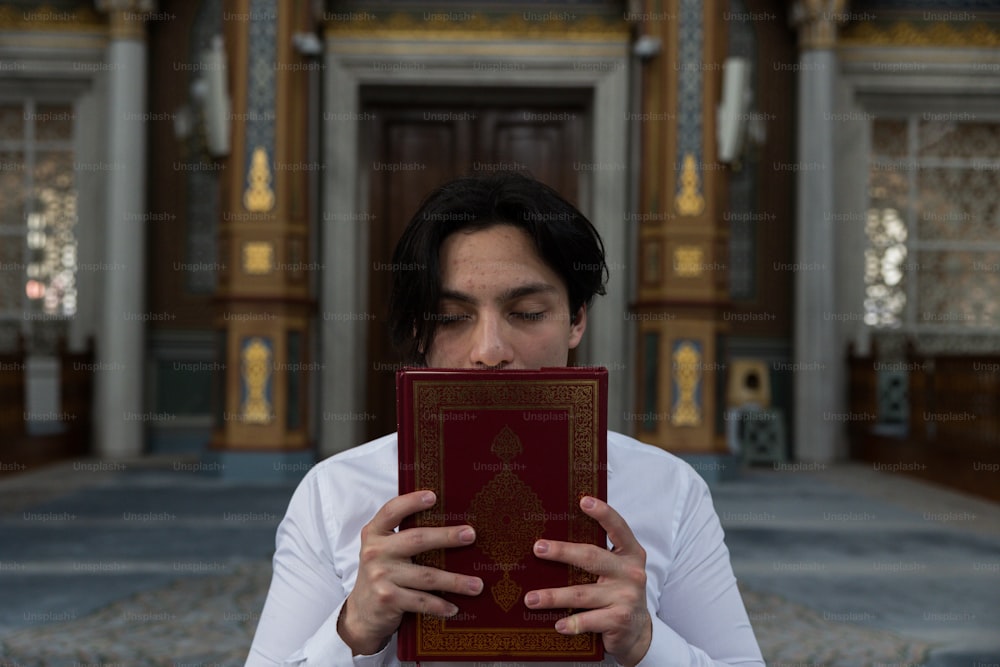 a man holding a book in front of his face